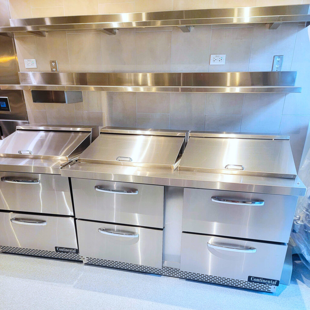 Spotless commercial kitchen with stainless steel prep tables and shelves, professionally cleaned by Cyclone Cleaning & Janitorial in Santa Clarita, CA.