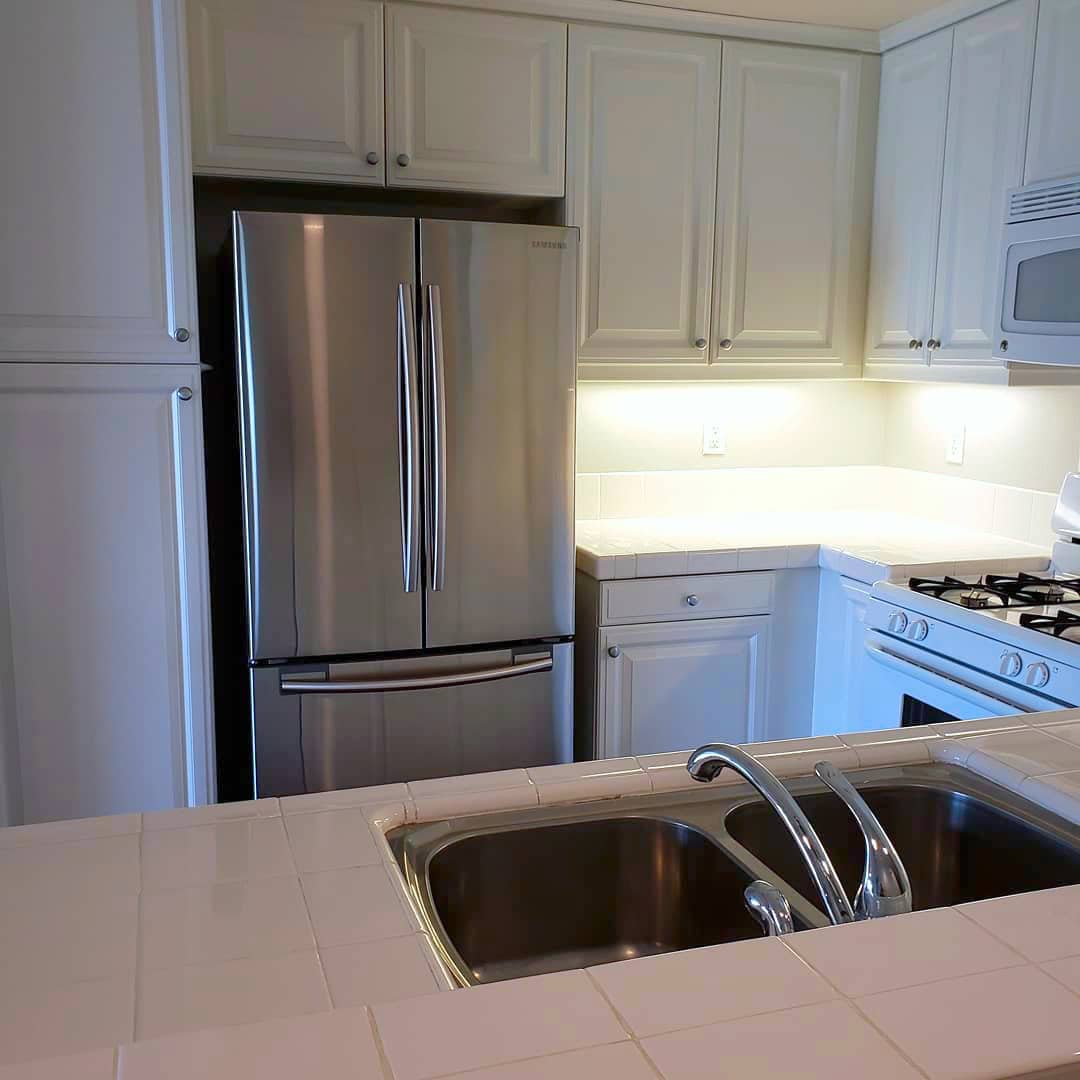 Modern kitchen with sparkling stainless steel appliances and immaculate white countertops, maintained by Cyclone Cleaning & Janitorial.