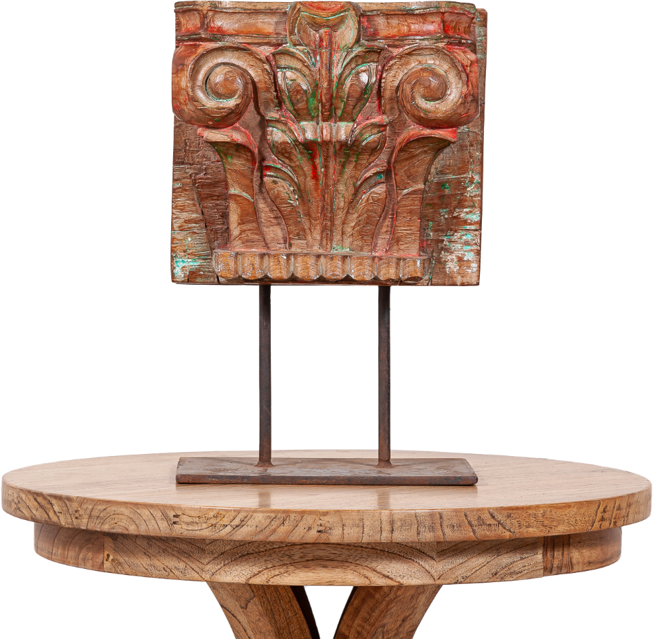 Hand-carved wooden panel with intricate floral details mounted on a rustic wooden pedestal table, showcasing artisan craftsmanship and timeless charm.