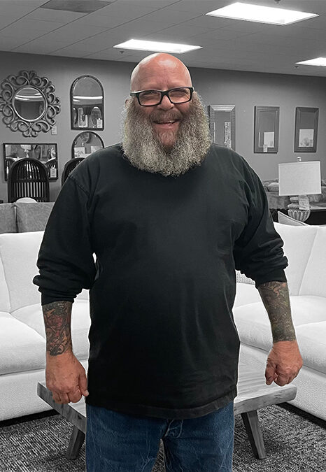 A photo of owner and operator Tony Peyser standing inside the store Furniture With Attitude.