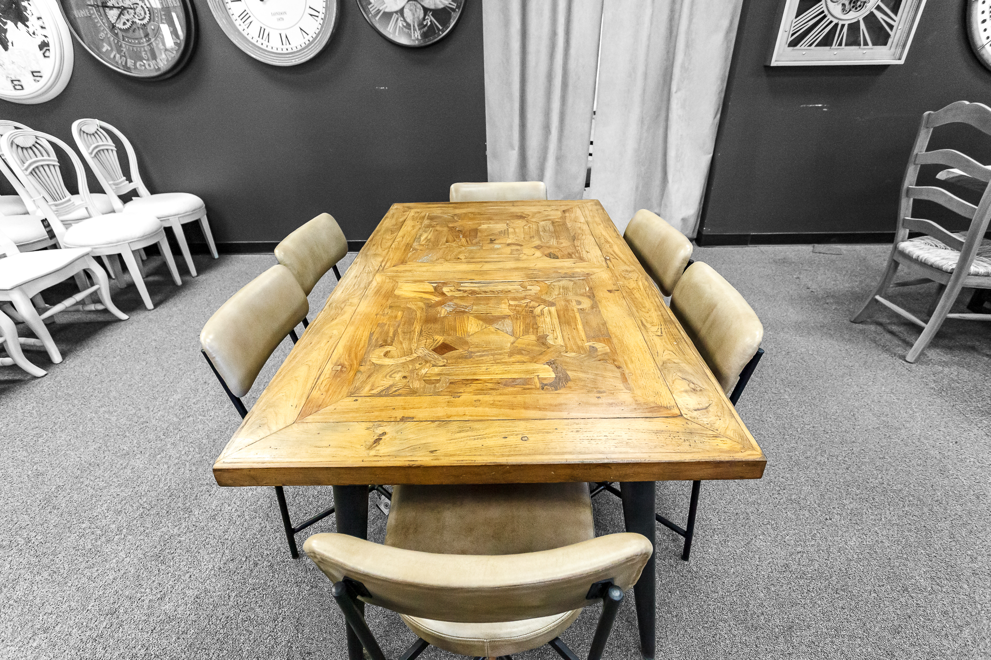 A clean-lined light wood table paired with round leather barrel chairs.