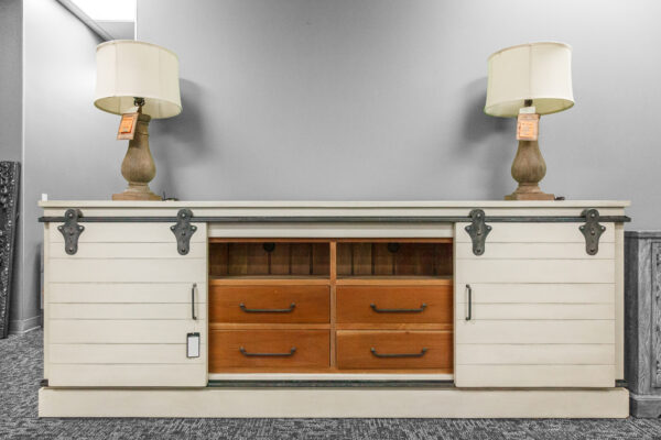 Two-tone sliding barn door console in white and natural wood tones, styled with matching lamps and set against a neutral wall.