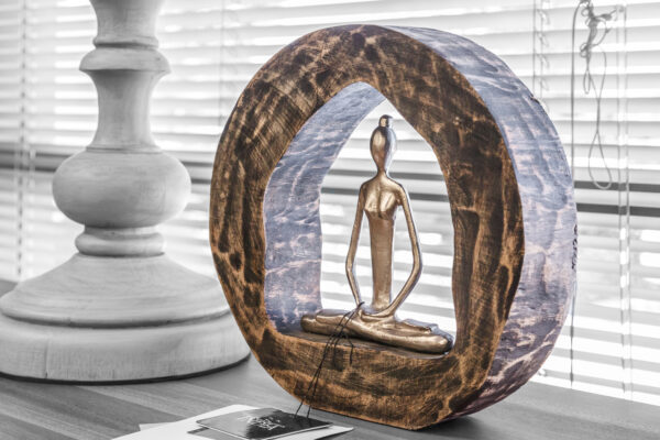 Hand-carved wood and metal meditation sculpture displayed near a window, surrounded by natural light and minimalist decor.