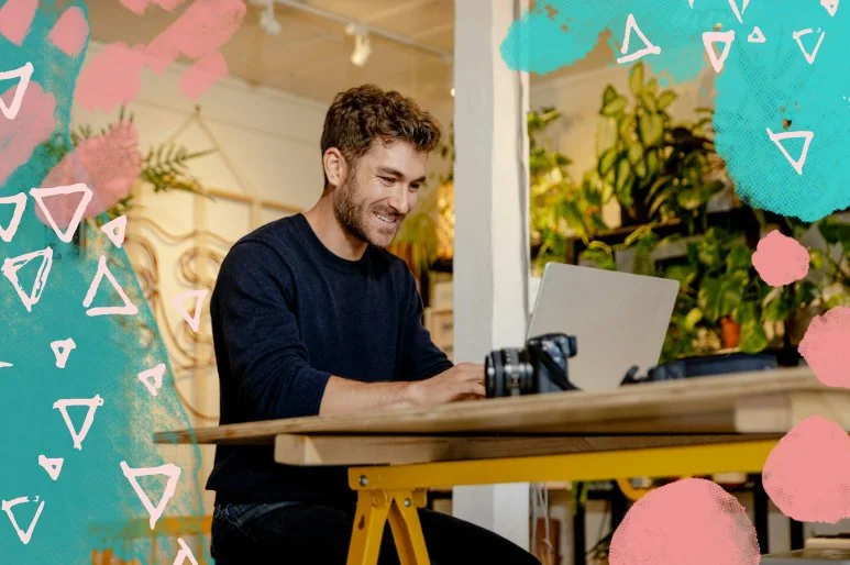 Photographer smiling and working on his computer in a trendy cafe