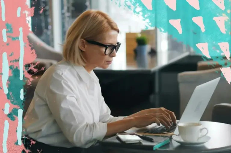 A middle-aged business woman concentrating while working on her laptop in a cafe.